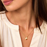 Gold-toned Figaro chain necklace with a smooth, teardrop-shaped pendant featuring a curved inlay of clear sparkling stones.