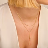Gold-toned Y-shaped necklace with two beaded chains. The lower chain forms a drop with three clusters of two beads each.