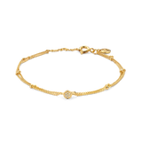 Yellow gold plated layered bracelet with a beaded chain and a central circular charm pavé-set with clear stones.