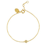 Delicate gold-toned chain bracelet with a small flower charm featuring clear stones. Includes a clasp and branded tag.