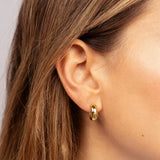 A single gold-toned hoop earring with a raised rose design on its front surface.