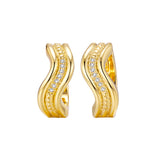 Gold-toned wavy hoop earrings with a central row of clear stones, bordered by textured and smooth bands.