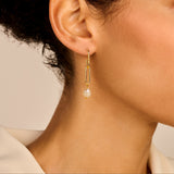 Gold-toned dangle earring with a crystal-studded hoop, an elongated link, and an off-white irregular pearl.