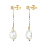 Pair of yellow gold plated drop earrings with square studs, clear stone embellishments, and white baroque pearls.