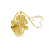 Gold-toned necklace with a ribbed, fan-shaped leaf pendant featuring a vertical line of seven clear stones down its center.