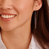 Silver-toned threader earring with two dangling bars; one is plain, the other features a line of clear stones.