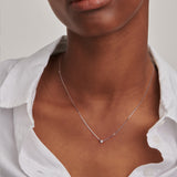 White-plated delicate chain necklace with a single small round diamond pendant in a bezel setting.