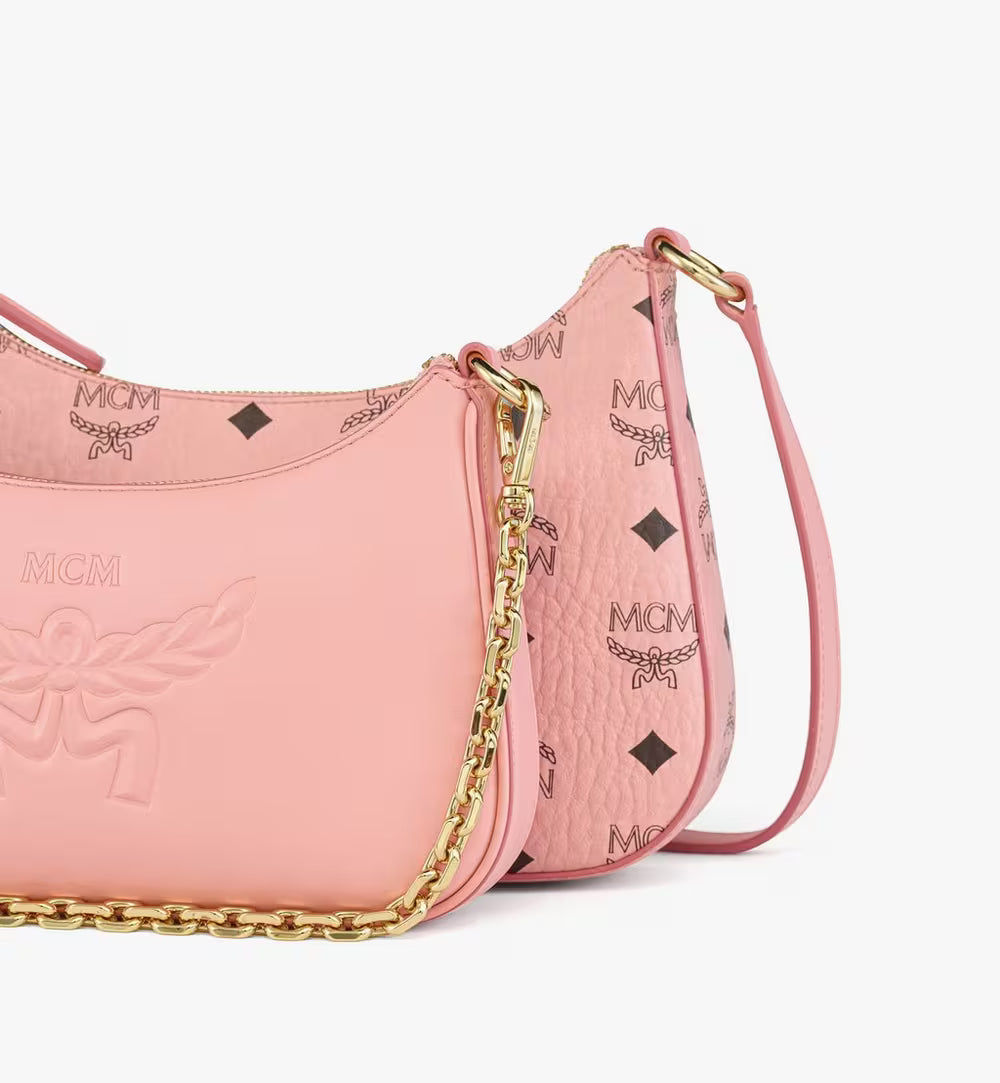 Pink handbag with gold chain detail on a white background.