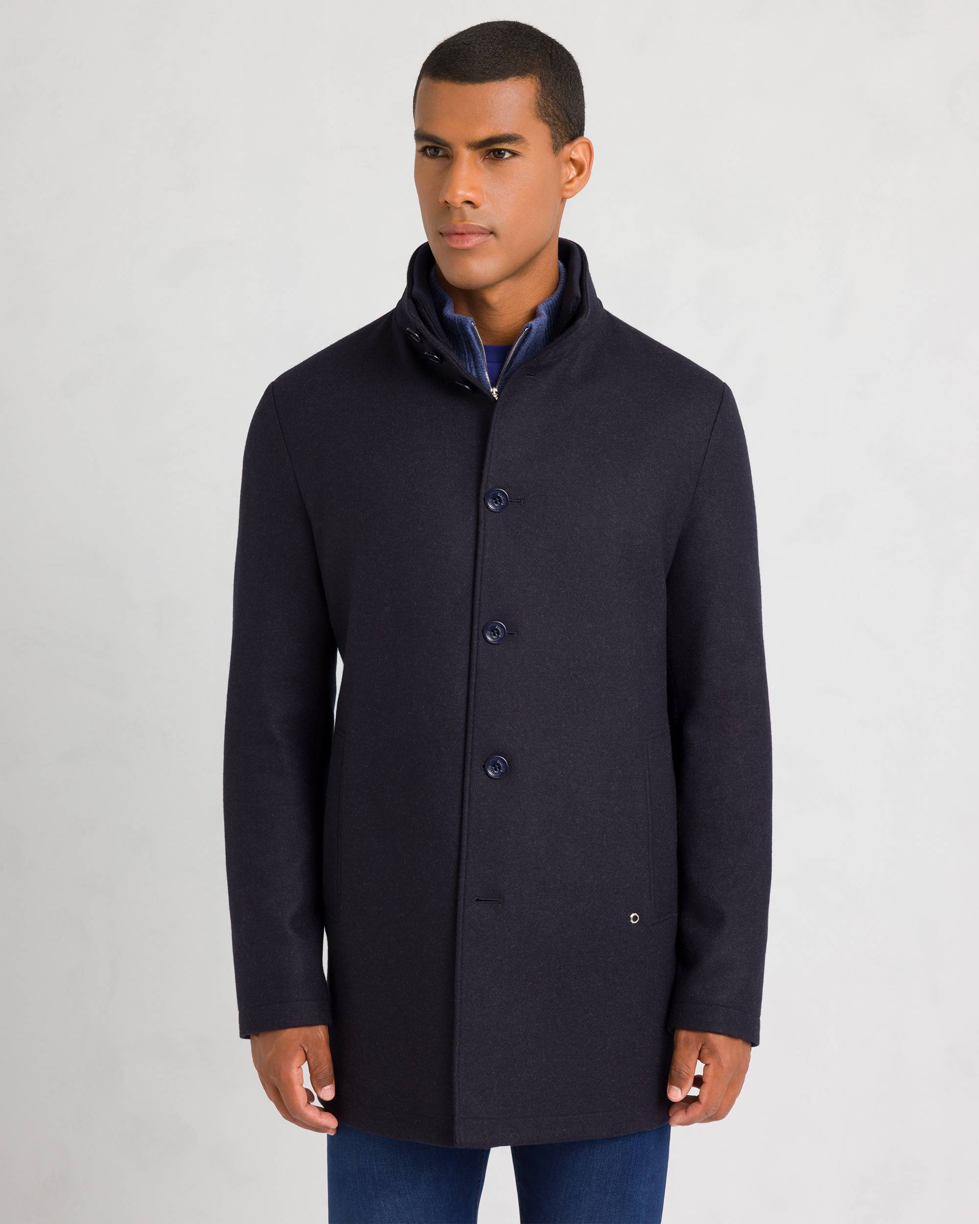Dark blue men's sport jacket with a stand collar and four-button concealed front placket, featuring two vertical welt pockets