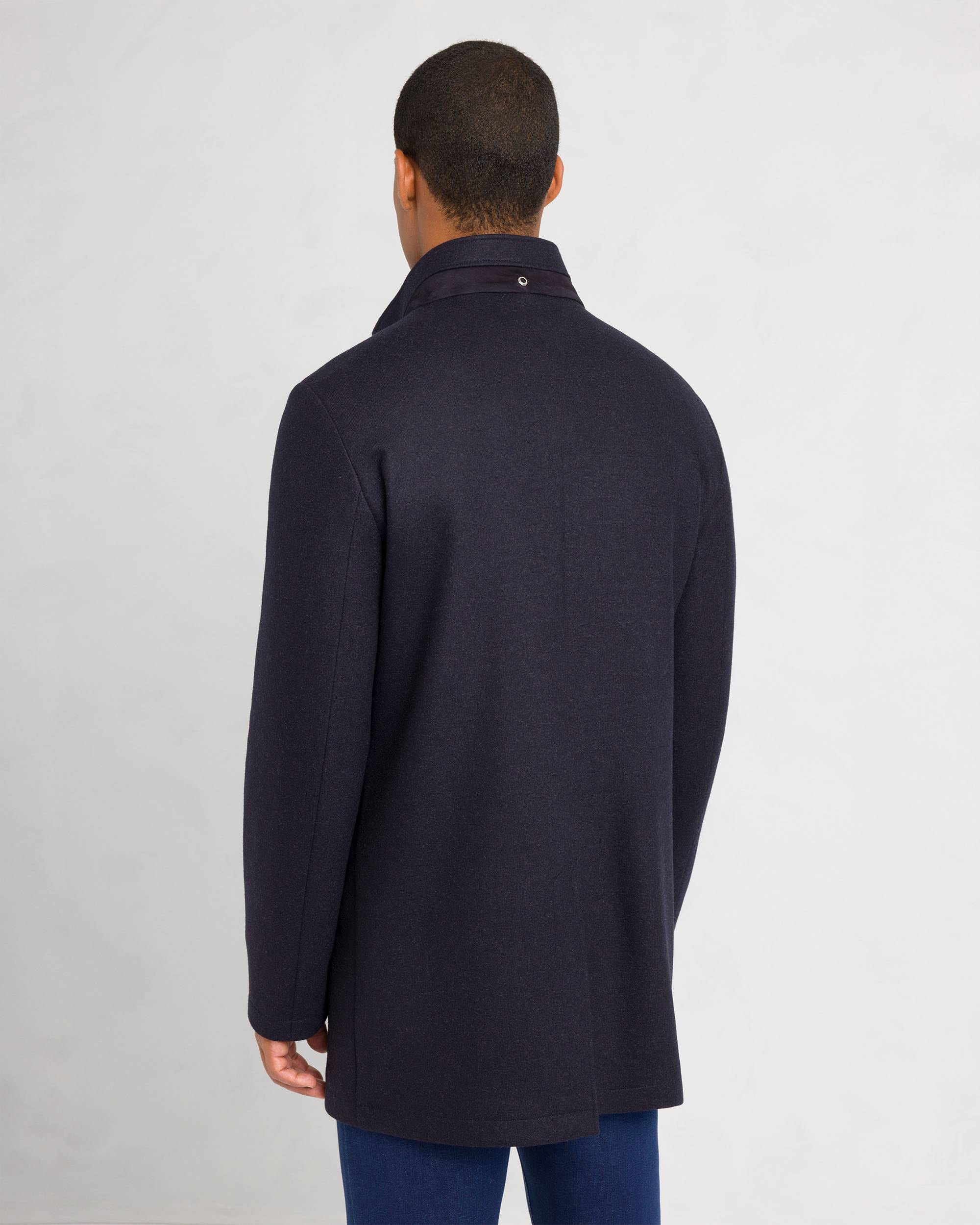 Dark blue sport jacket with a stand collar, darker blue suede-like trim, and a silver-toned snap button on the collar.