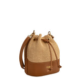 Piumelli Meg Tobacco bucket bag in woven straw and leather with gold hardware and drawstring closure. Available for Online Purchase