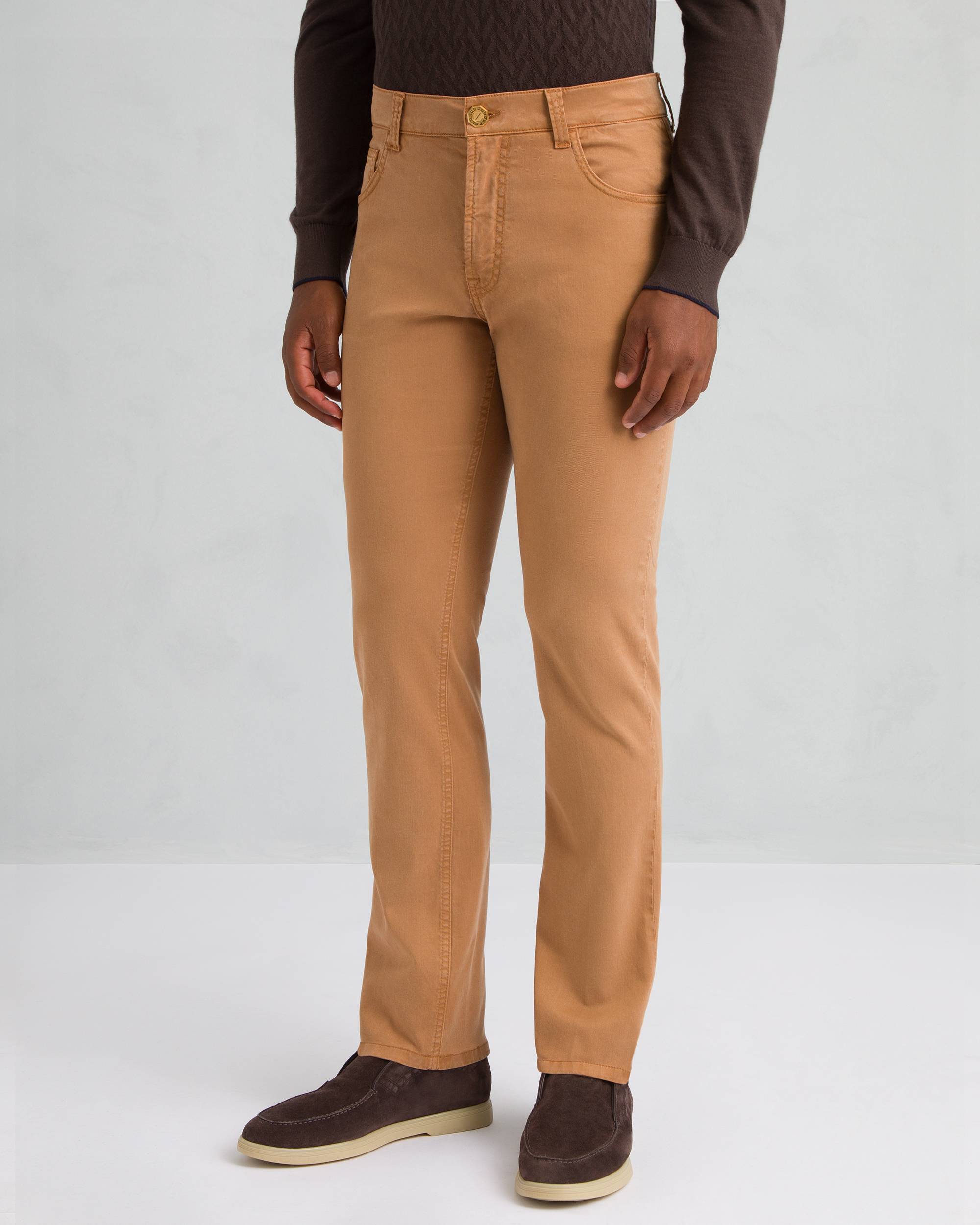 Men's light brown straight leg trousers with five pockets, belt loops, and a gold-toned button closure.