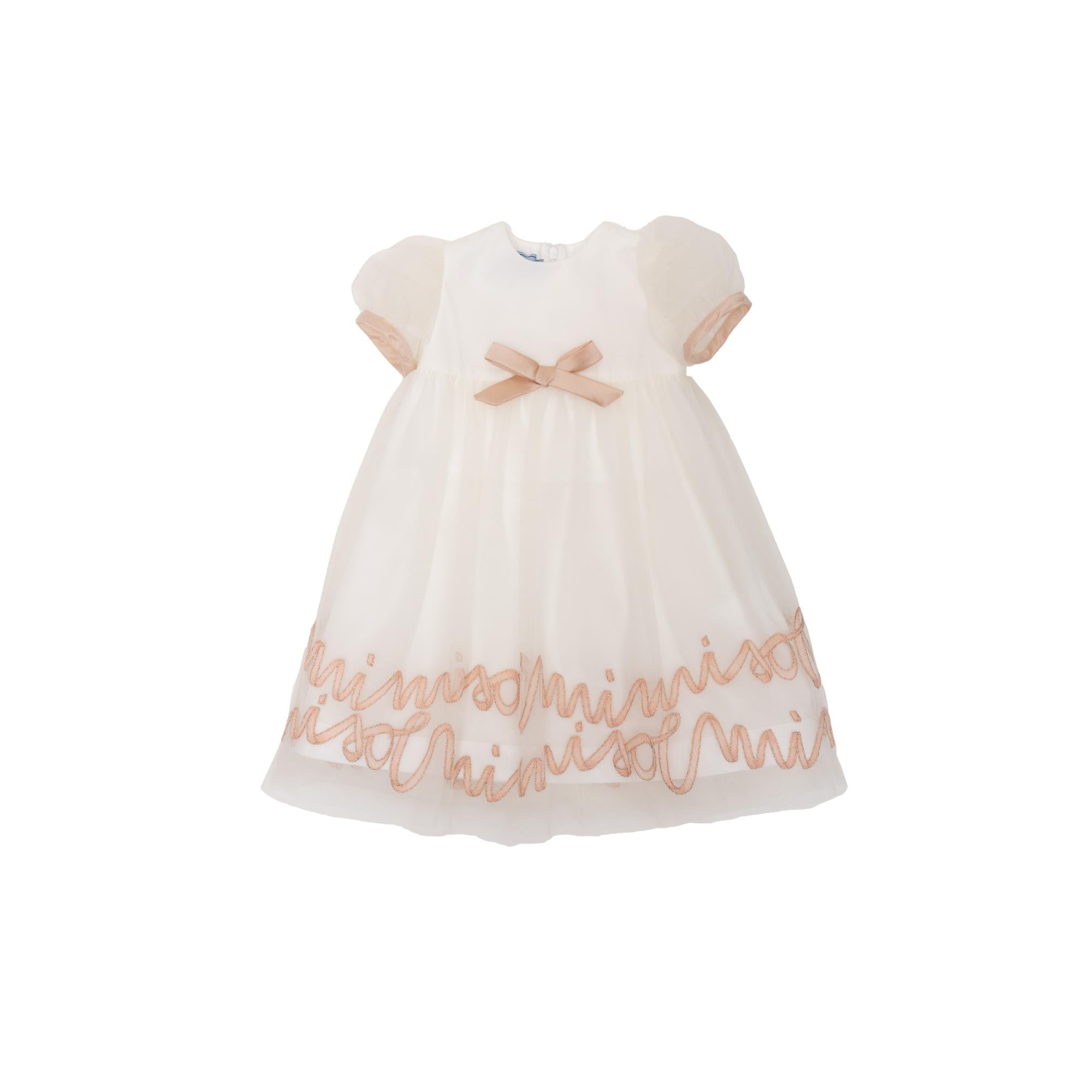 Ivory baby dress with puffed sleeves, a small beige bow on the bodice, and beige embroidered text along the skirt hem.