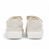 Rear heel view of a pair of kids' athletic sneakers, showing a white faux-leather back panel topped with a black pull loop and a small circular gold-tone MK badge.