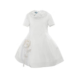 A high-quality ivory white girls' formal dress by MiMiSol featuring short sleeves, a Peter Pan collar with a bow, and a large white fabric rose appliqué on the skirt.