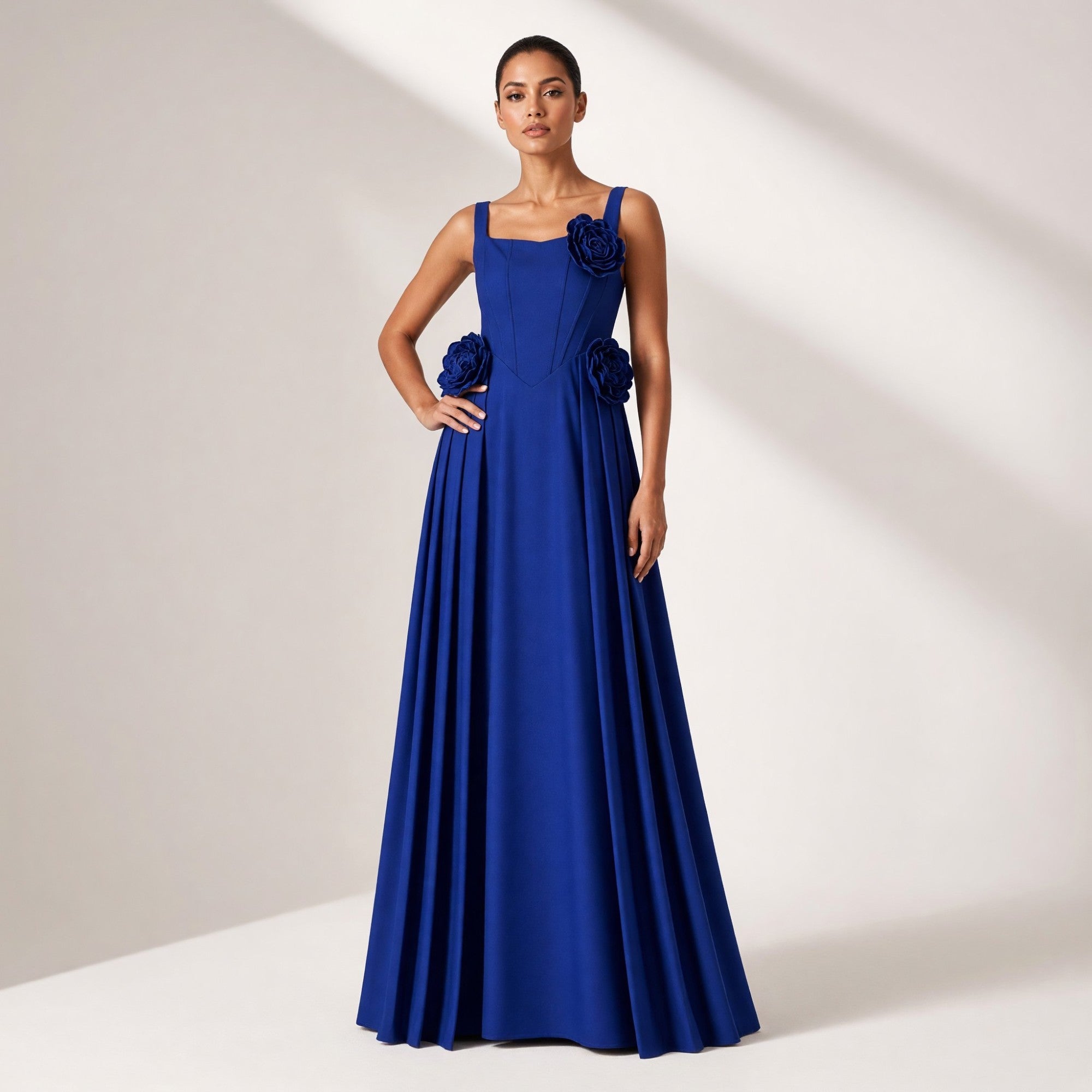 Blue floor-length dress with square neckline, wide straps, fitted bodice with cut-outs, three large fabric floral appliques,