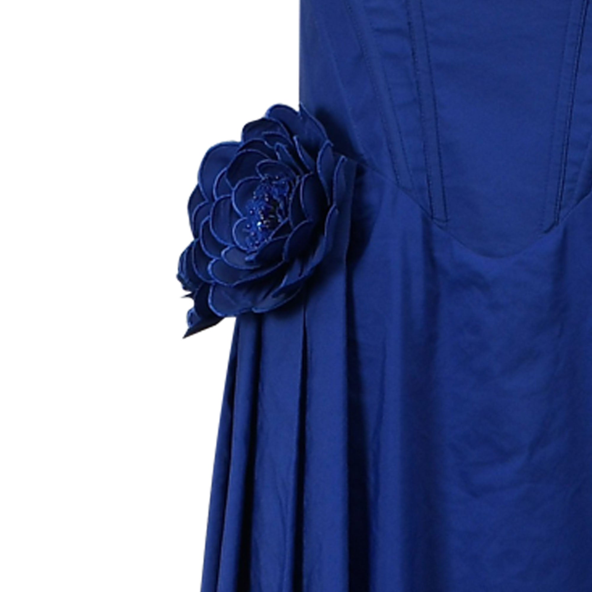 Vibrant blue dress with a large, layered fabric flower appliqué on the side. The flower's center is embellished with blue bea