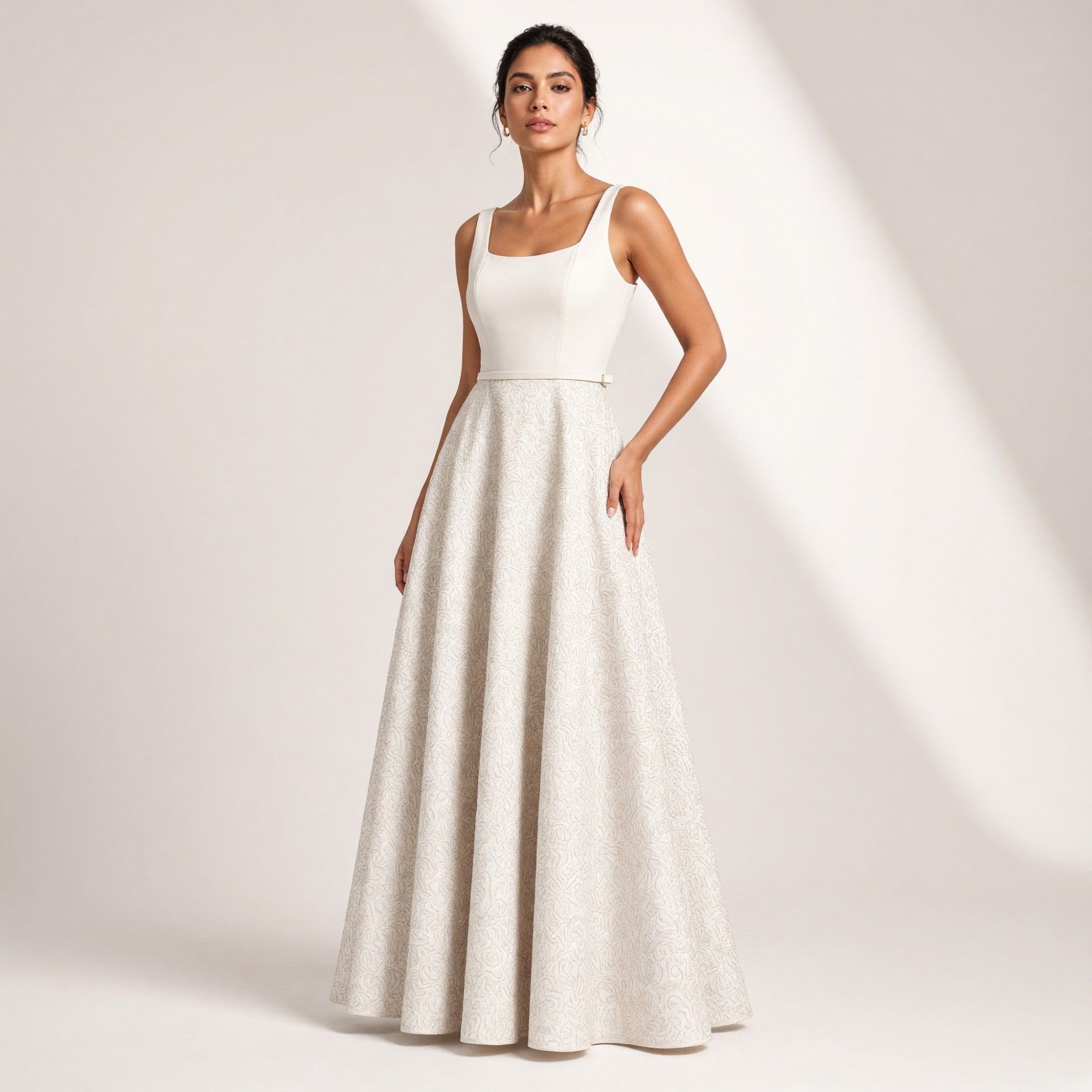 White sleeveless maxi dress with a square neckline. It has a smooth bodice, a thin waist belt, and a full skirt with a subtle