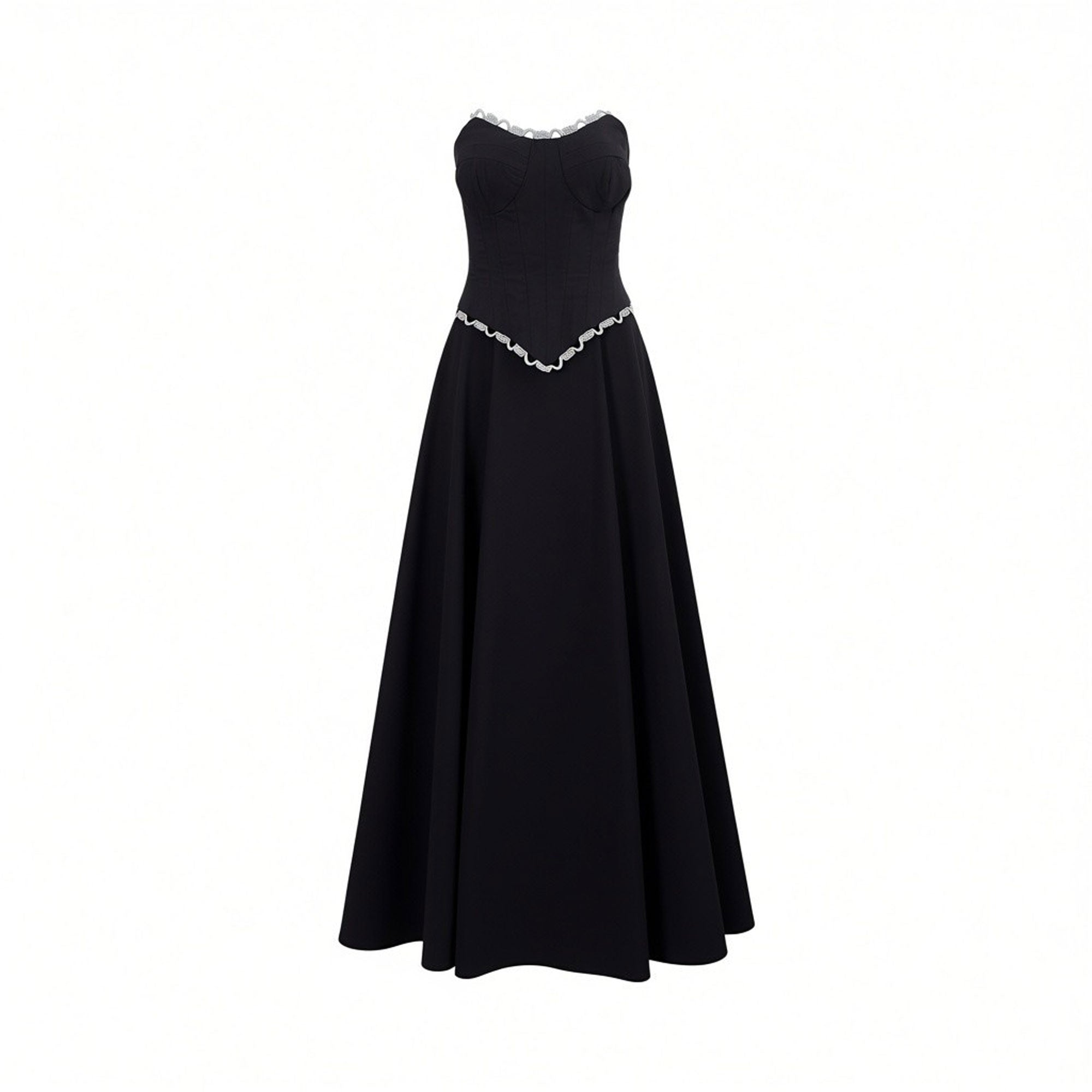 Black strapless top with white ruffled sweetheart neckline and V-waist, paired with a long black flowing skirt.