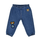 Close-up of the blue denim baby jeans featuring an elasticated waist and colorful "WOW," peace sign, and teddy bear patches.