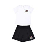 A Moschino Kid two-piece set including a white short-sleeved T-shirt and black pleated shorts, both featuring a Toy Bear logo.