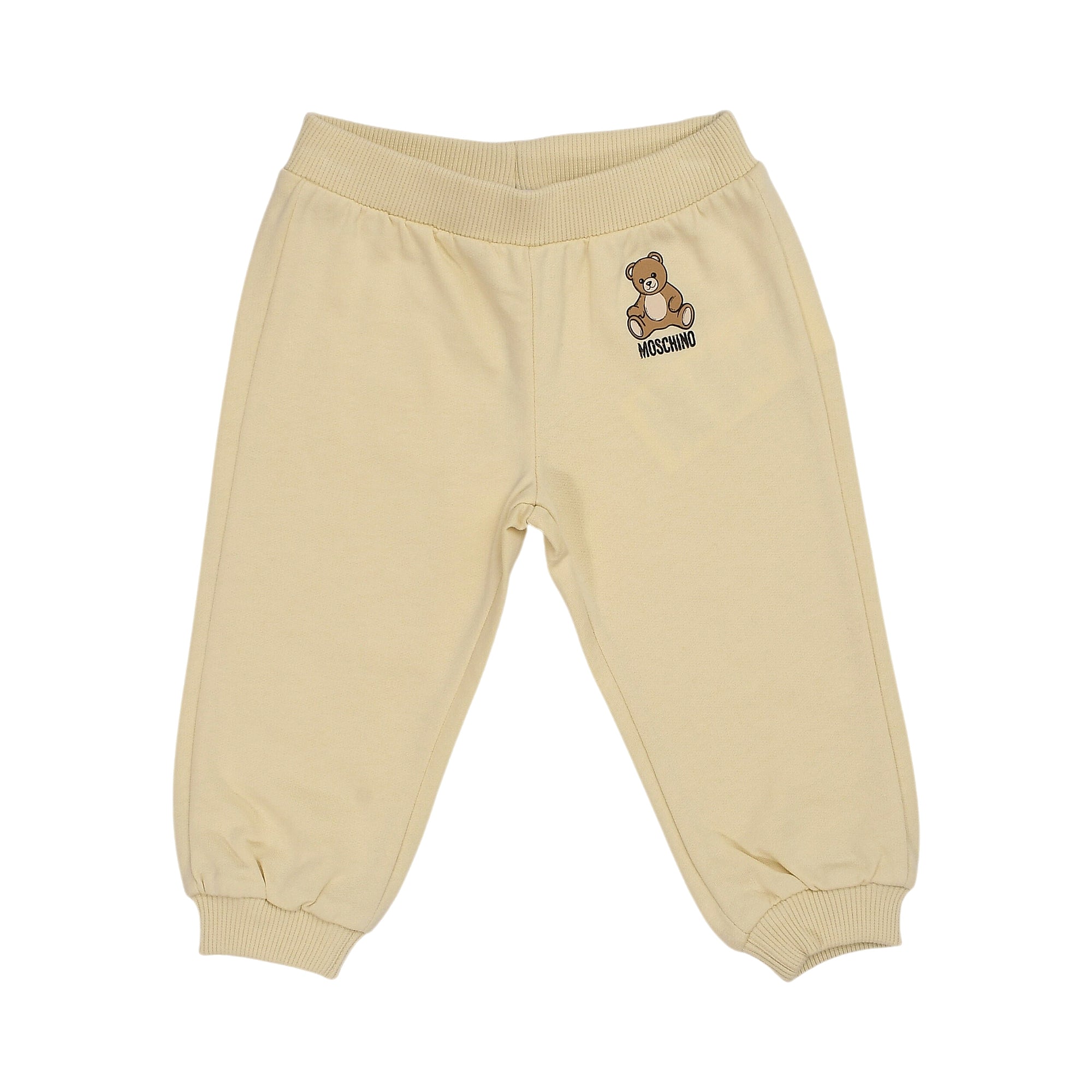 Beige jogging pants with ribbed waist and ankle cuffs, featuring a brown teddy bear and Moschino logo print on the left thigh