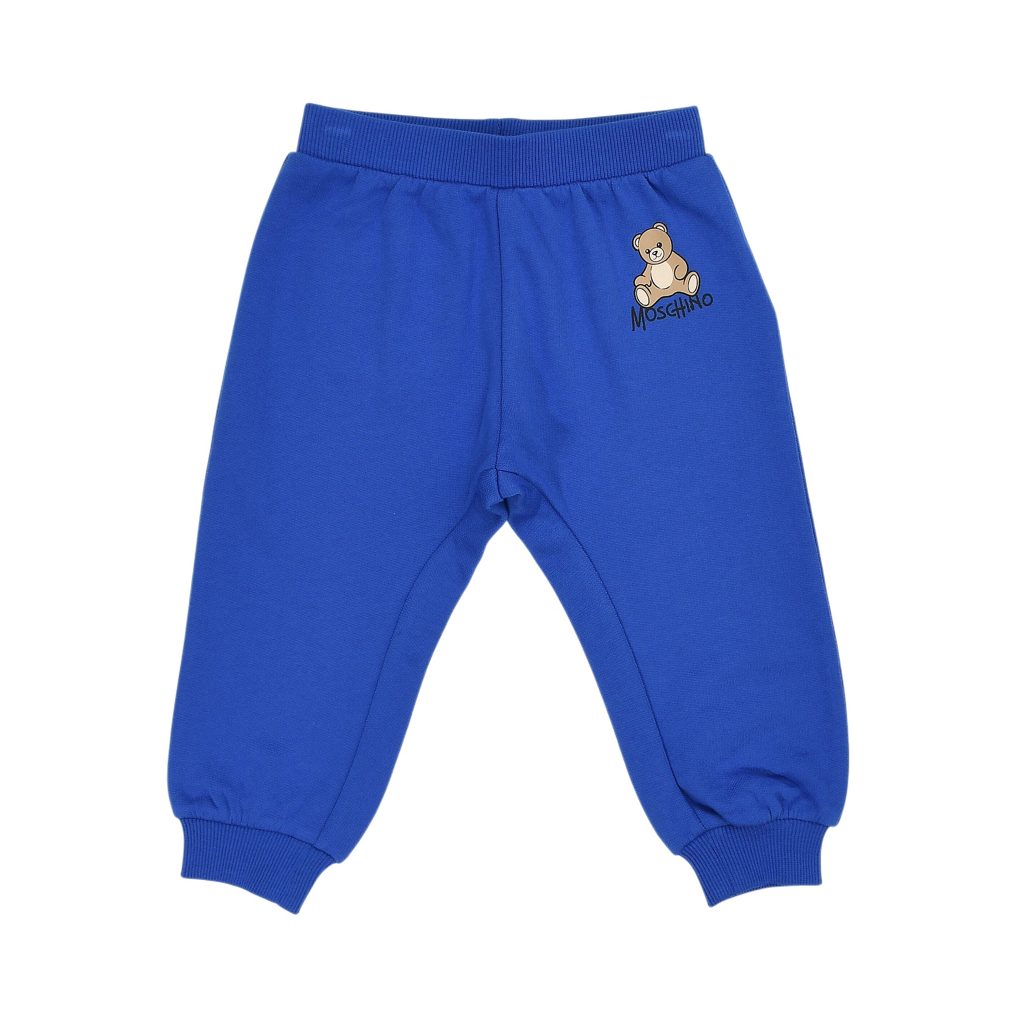 Blue jogging pants with ribbed waist and cuffs, featuring a teddy bear graphic and "MOSCHINO" text on the left thigh.