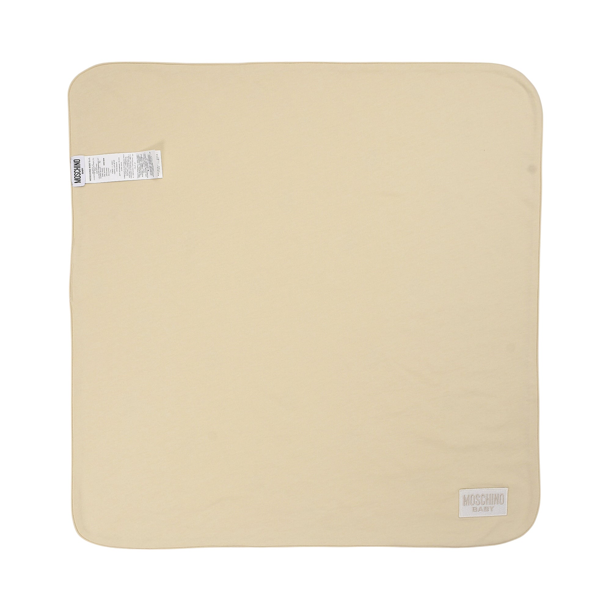 Smooth beige blanket with rounded corners. White 'MOSCHINO BABY' label on the bottom right, care tag on the top left.