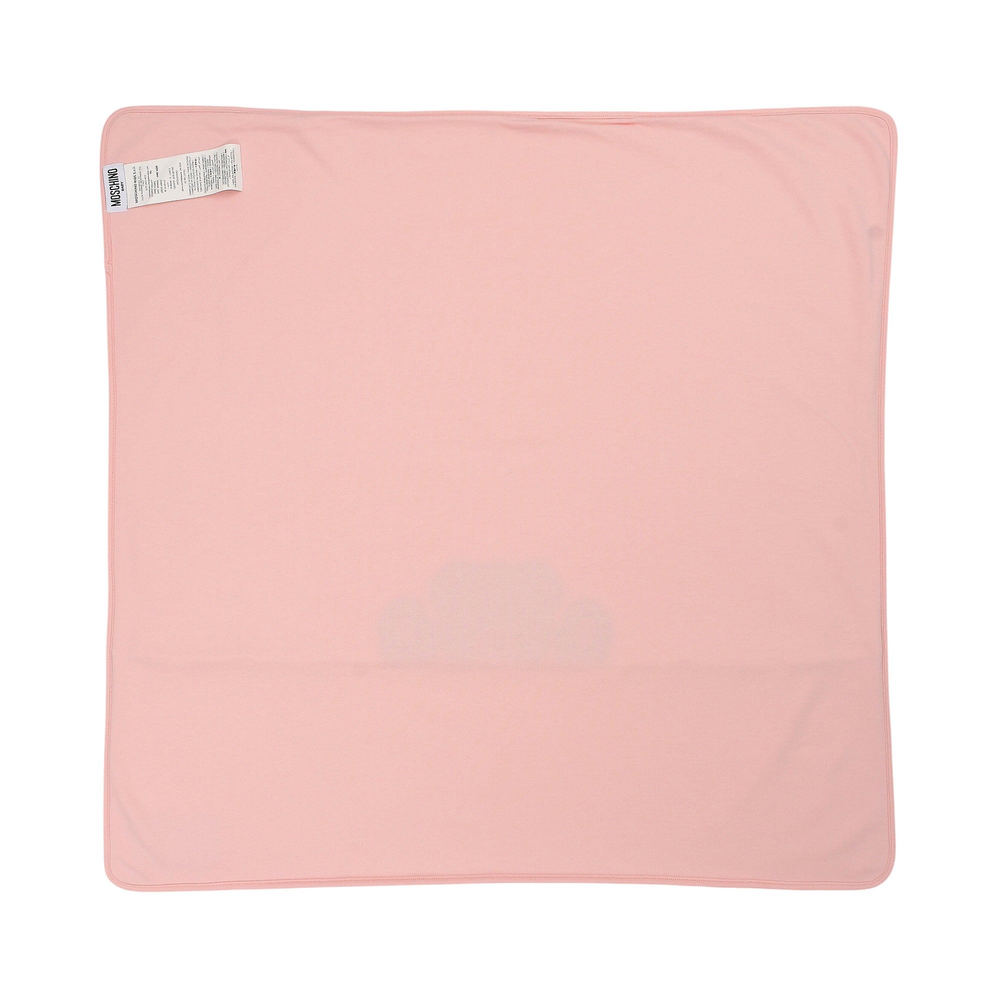 Light pink rectangular blanket with rounded corners, stitched edges, a white Moschino label in the top left, and a faint clou