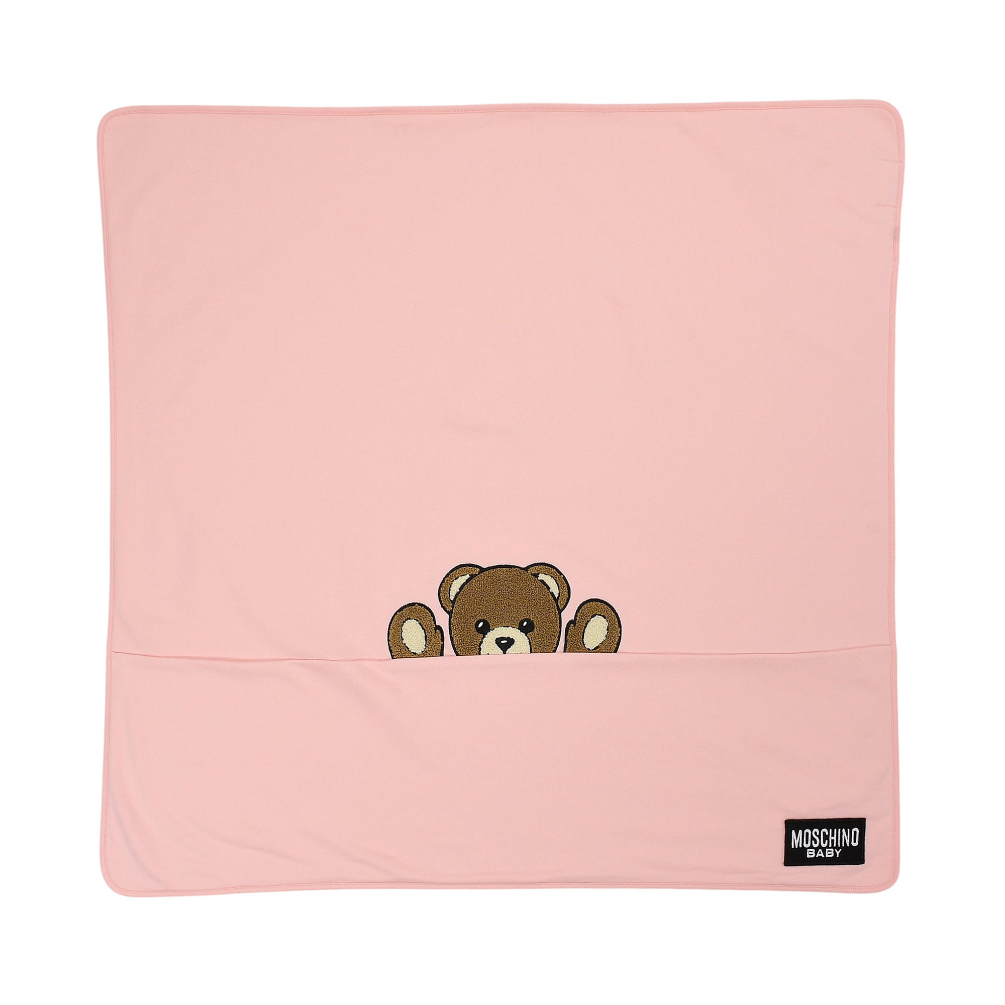Pink knit baby blanket with rounded corners, featuring a brown embroidered teddy bear peeking from a horizontal seam.