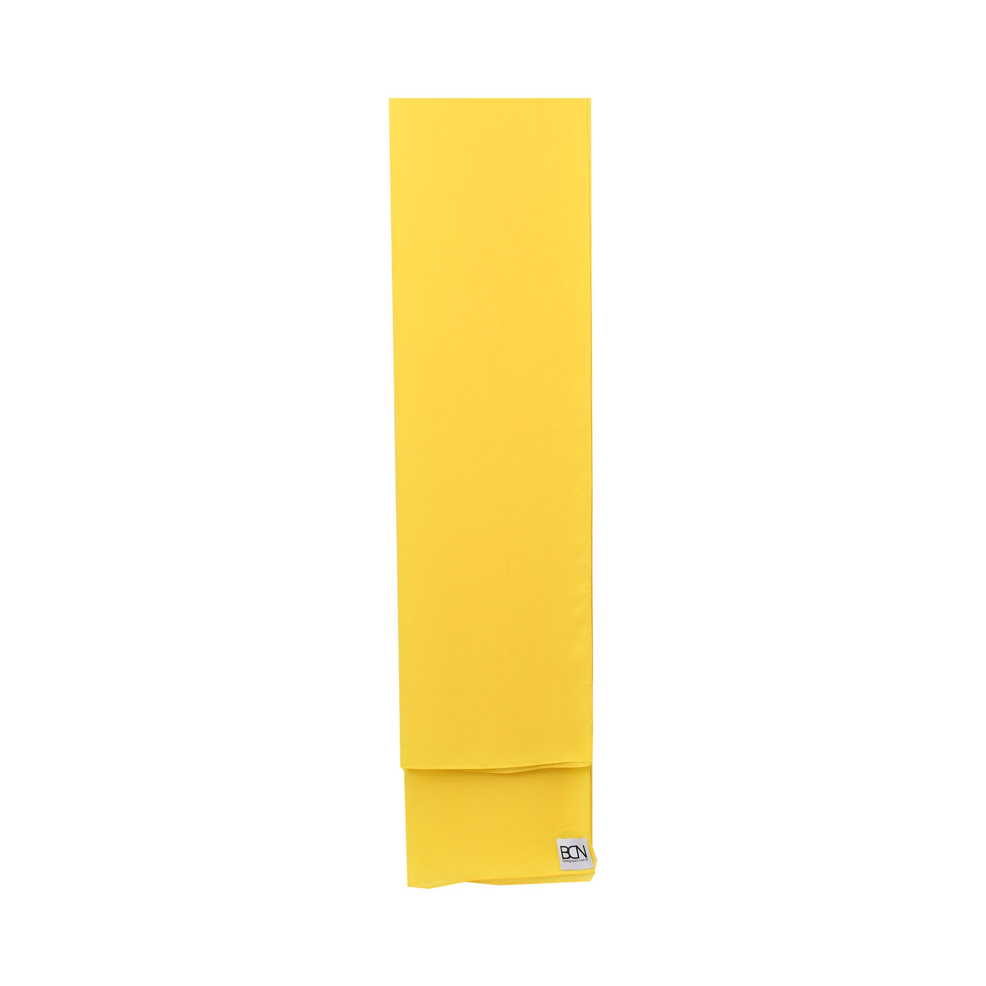 A folded bright yellow kaftan with a small white 'BCN' tag on the bottom right.