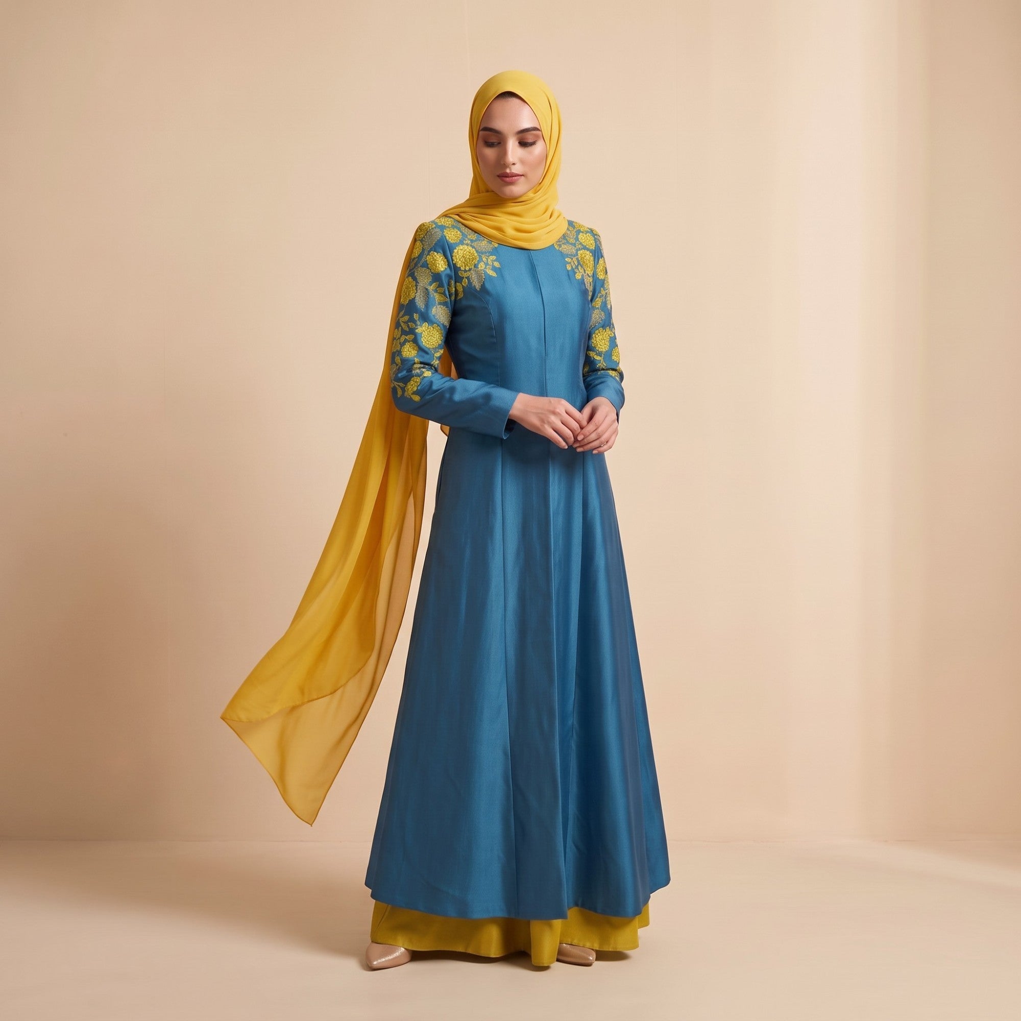 Teal blue kaftan with long sleeves, yellow floral embroidery on shoulders and sleeves. Yellow underlayer and matching flowing