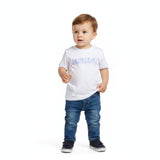 A smiling toddler modeling the Missoni white logo T-shirt paired with matching pink shorts against a seamless white studio background.