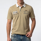 Khaki men's short-sleeved polo shirt with a white collar, two-button placket, and aviation-themed patches on the front.
