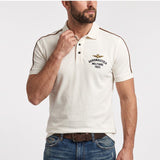Off-white short-sleeved polo shirt with a collared neckline, two dark buttons, and a gold-toned embroidered emblem on the che