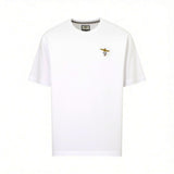 Off-white short-sleeved crew neck t-shirt with a small embroidered gold-toned winged emblem, black 'A.M.', and a red circle o