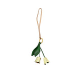 A handcrafted leather charm by MUNI featuring two magenta tulip buds and green leaves hanging from a gold ring and a tan leather cord, shown on a white background.