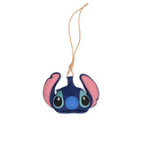A handcrafted leather bag charm by MUNI shaped like the face of Stitch from Lilo & Stitch, featuring layered blue and pink leather details and a tan hanging cord.