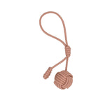 Leather bag charm by MUNI featuring a large spherical monkey fist knot at the bottom, smaller coiled knot accents, and a long attachment loop against a white background.