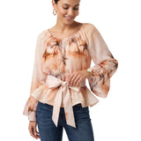 Studio shot of a model wearing the peach Milva Mi tropical print belted chiffon blouse, paired casually with classic dark-wash denim jeans.