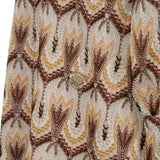 Multicolor knit dress with cream, gold-toned, brown, and dark red zigzag pattern, open lace texture, and a gold-toned button.