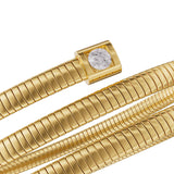 A close-up macro shot focusing on the square gold-plated bezel terminal housing a brilliant cut clear solitaire crystal alongside the polished ridges of the Tubogas chain structure.