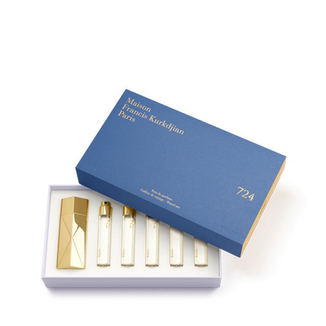 The Maison Francis Kurkdjian 724 travel set displayed in an open blue presentation box with gold lettering, neatly housing the gold Globe Trotter case and five 11ml refills.