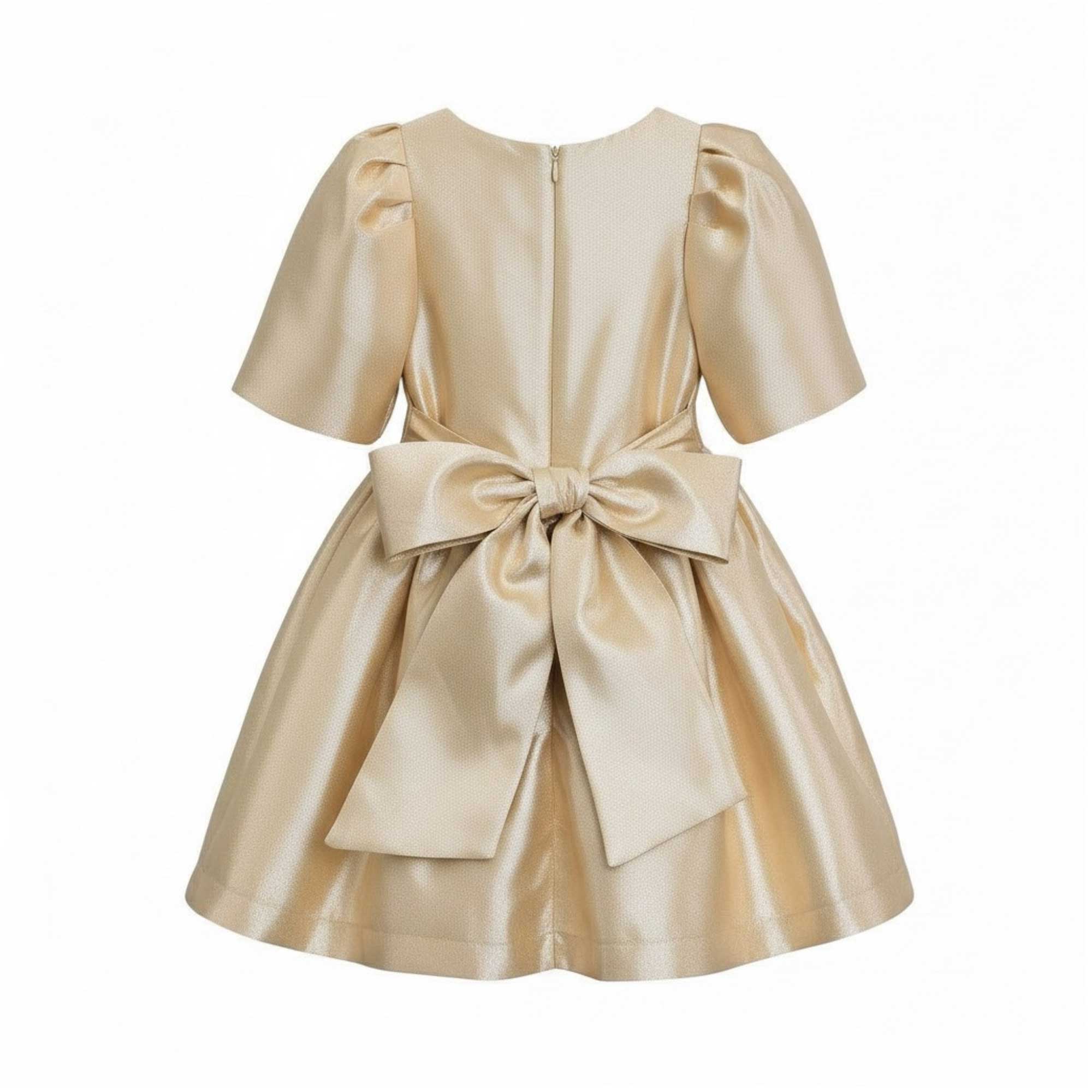 Back full-length view of the Mamaluma girls gold lurex dress highlighting the large, structured statement bow at the waistline and a clean concealed zipper.
