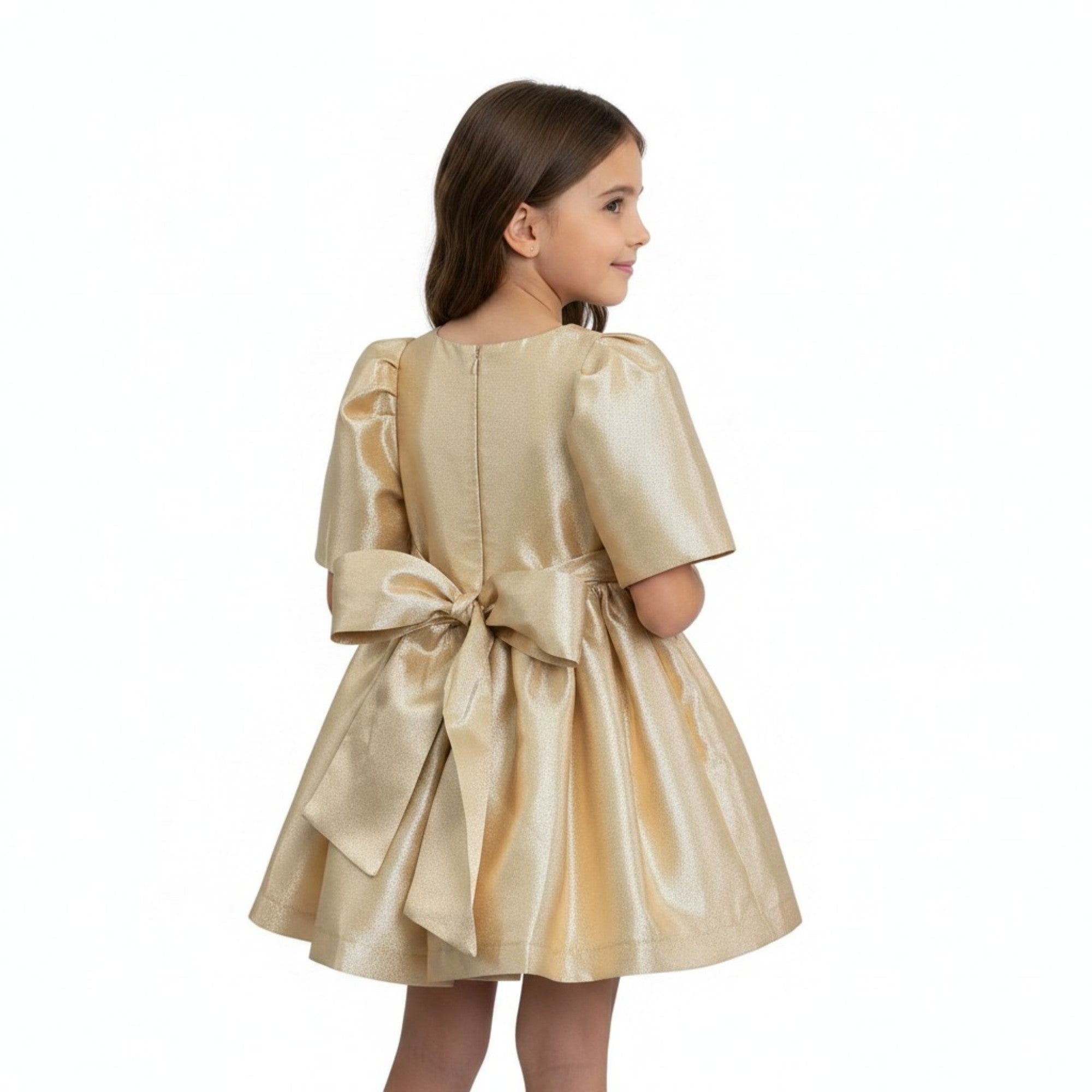 Young girl wearing a gold dress with a bow on a white background.