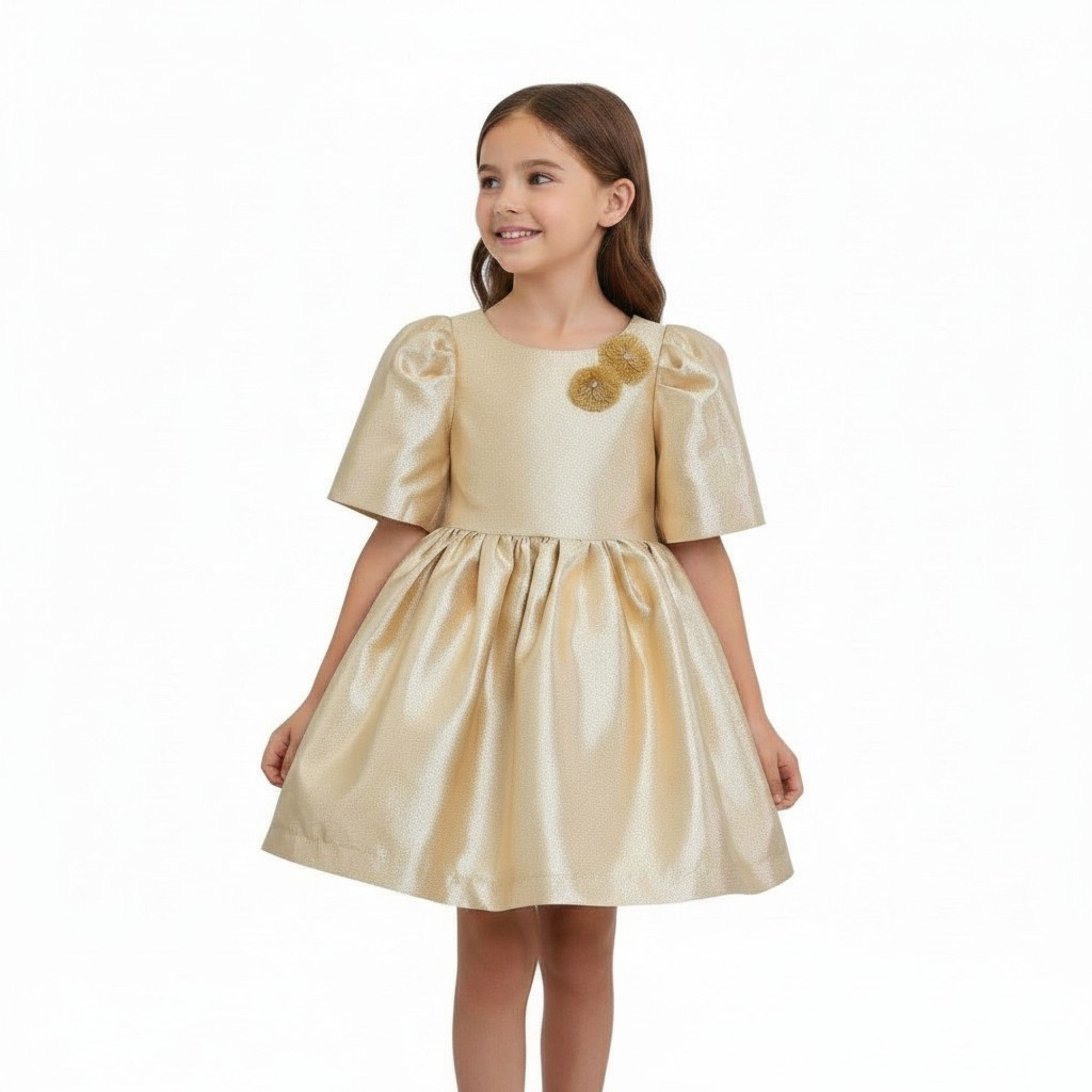 Young girl wearing a gold dress with floral details on a white background.