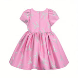 Back full-length view of the Mamaluma girls pink dress highlighting a large, structured satin statement bow at the waistline and a clean, concealed zipper closure.