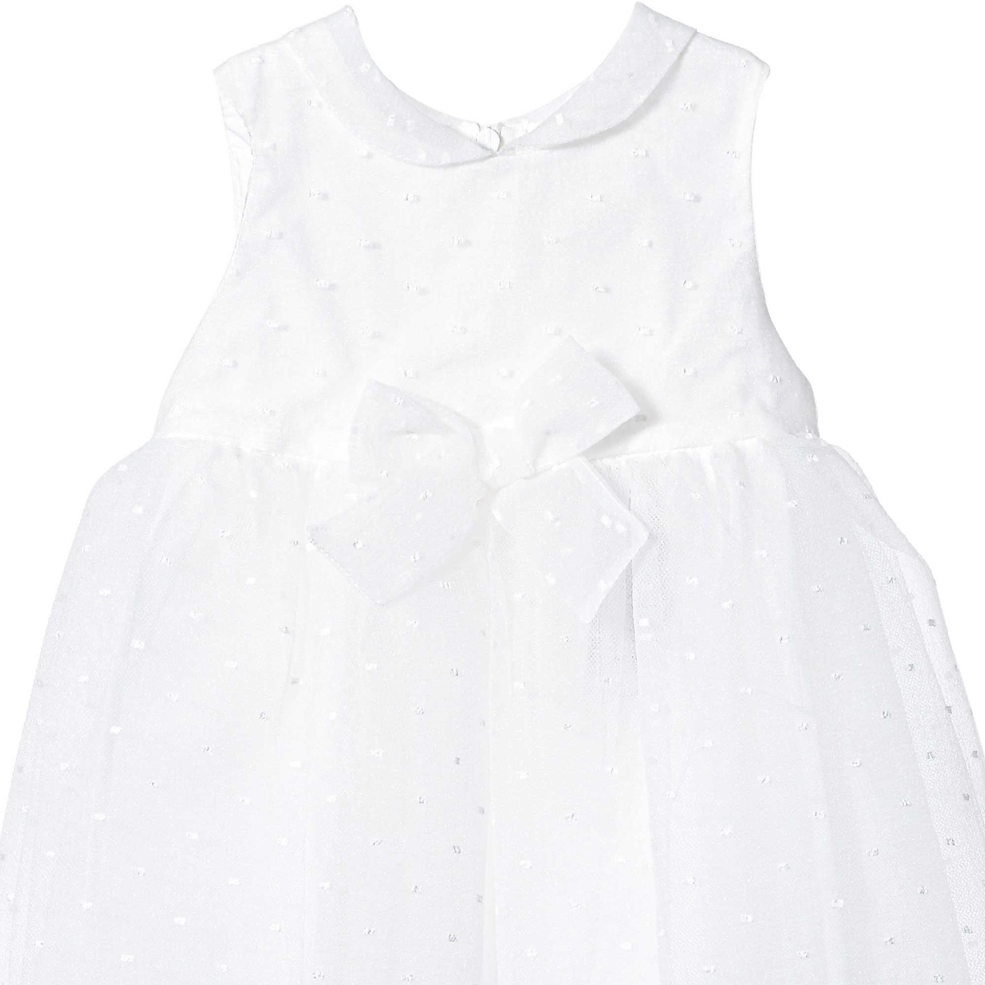 Close-up detailed shot of the Mamaluma girls white dress showcasing the intricate Swiss dot pattern fabric texture, Peter Pan collar, and central front waist bow.