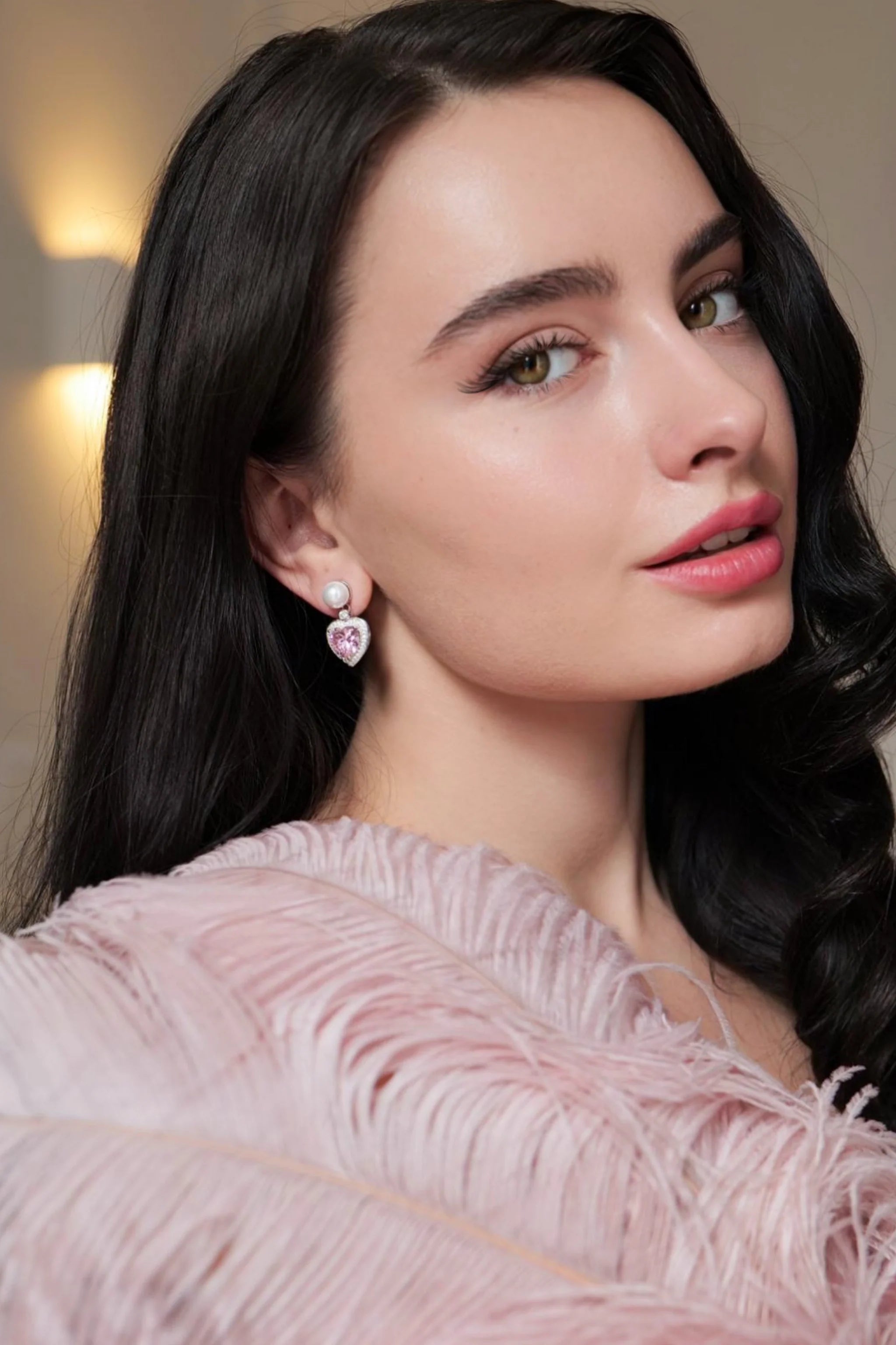 Silver-toned drop earring with a white pearl stud and a pink crystal heart pendant framed by clear crystals.