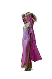 A woman stands on a balcony wearing a flowing magenta-purple robe with green embroidered trim and a matching headpiece, with a mountain and greenery in the background.